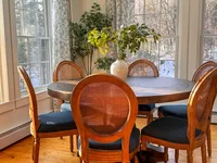 Sunlit dining area with round table and garden views at Brookside Retreat