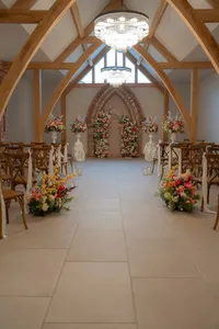 colourful wedding floral arch for wedding ceremony and plinth floral arrangements inside wedding venue