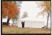 Michigan wedding photography of a bride and groom hugging outside of a large white tent.
