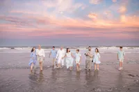 Extended family walking together during a pink and orange sunset