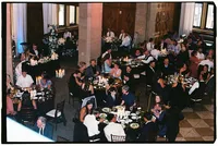 Candid wedding photo of guests sitting at tables eating food, by destination wedding photographer Grace Wan.