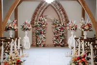 colourful wedding floral arch for wedding ceremony and plinth floral arrangements