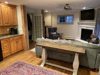 Den with kitchen counter, seating and fireplace at Brookside Retreat