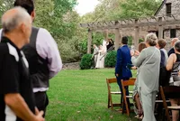Wedding Planners with Weddings & Events by Raina assist the bride down the stairs to the aisle