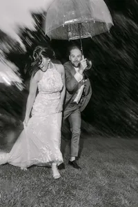 Couple dancing under a clear umbrella at night, black-and-white flash wedding photo with motion blur