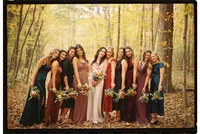 A bride smiles with her nine bridesmaids, by Grand Rapids wedding photographer Grace Wan.