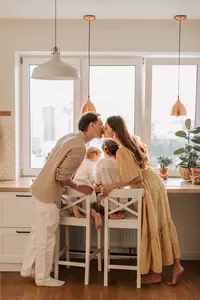 Couple sharing a kiss with their children nearby