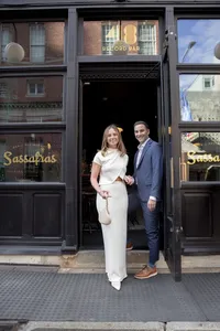 Couple standing outside Sassafras restaurant during their engagement session