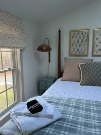 Second-floor bedroom with plaid bedding and guest towels at Brookside Retreat