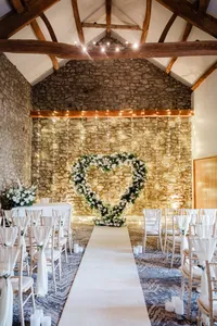 heart-shaped white rose wedding arch with fairy lights