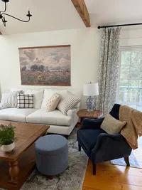 Living room seating area with large windows at Brookside Retreat