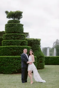 Couple standing among topiary hedges during their engagement session