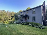 Brookside Retreat exterior and gravel drive in a wooded Vermont setting