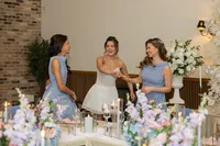 bride and bridesmaids at wedding table with pastel flower centrepieces