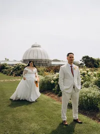 A bride stands behind her groom in preparation for their first look, shot by Michigan elopement photographer Grace Wan.