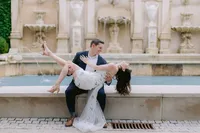 Couple embracing on a stone bench in a fountain courtyard during their engagement session
