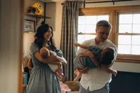 Grand Rapids family photographer Grace Wan captures a mother holding their newborn and a father holding their toddler inside their home.