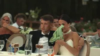 Wedding videography still of guests seated at dinner table during reception celebration