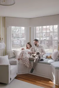Family with newborn and dog in a window seat