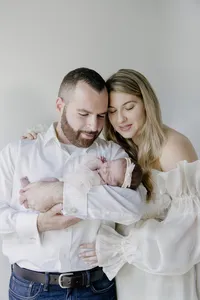 Parents holding their newborn baby during a studio portrait session