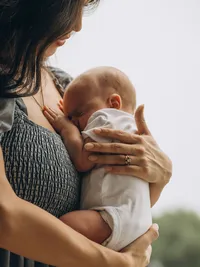 Close up portrait of a mother holding her newborn baby outside in Grand Rapids Michigan.