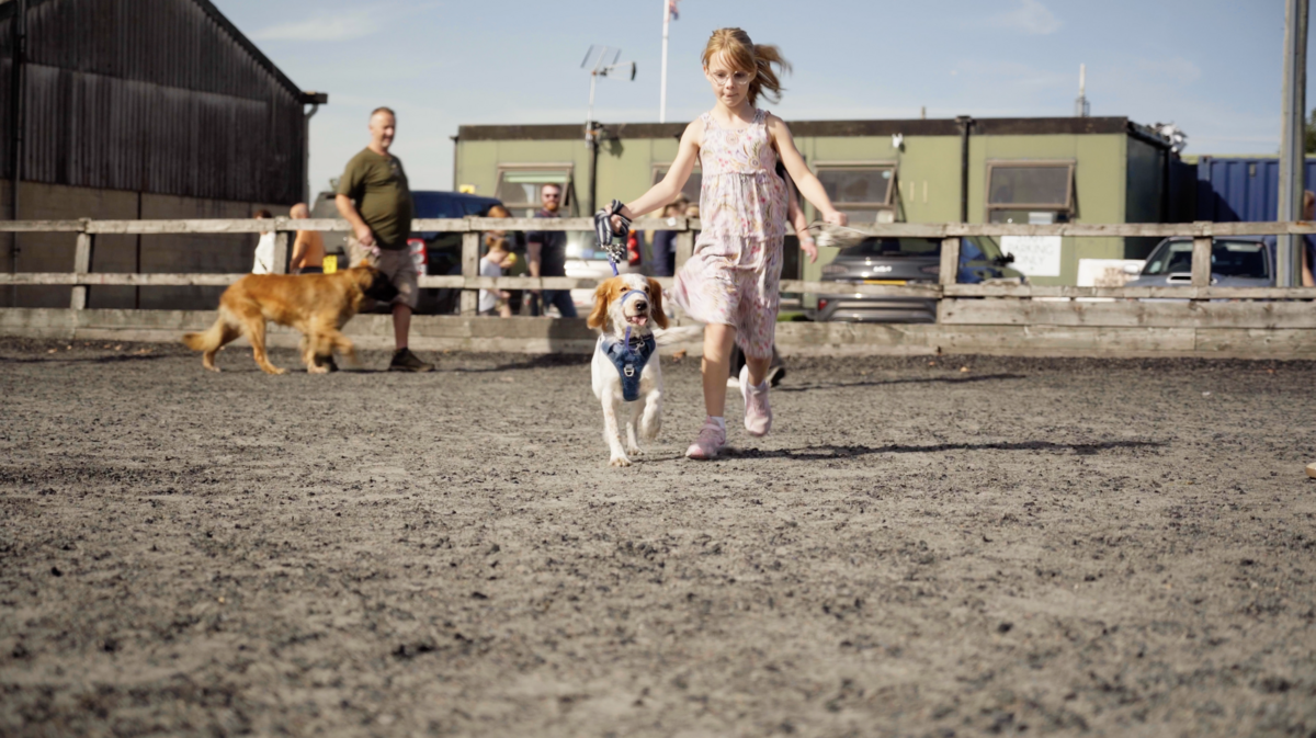 A girl running with her spaniel