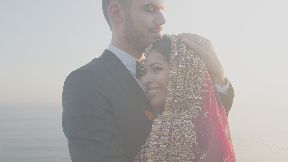 Bride and groom embracing by the ocean at their Stone Villa Uluwatu wedding in Bali