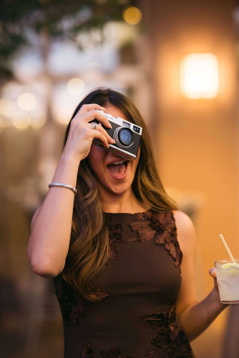 Wedding guest having fun photographing the celebration with a Camp Snap Pro camera
