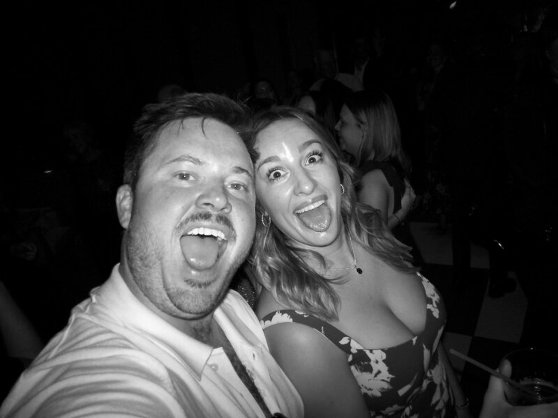 Two guests making funny faces for a candid wedding selfie