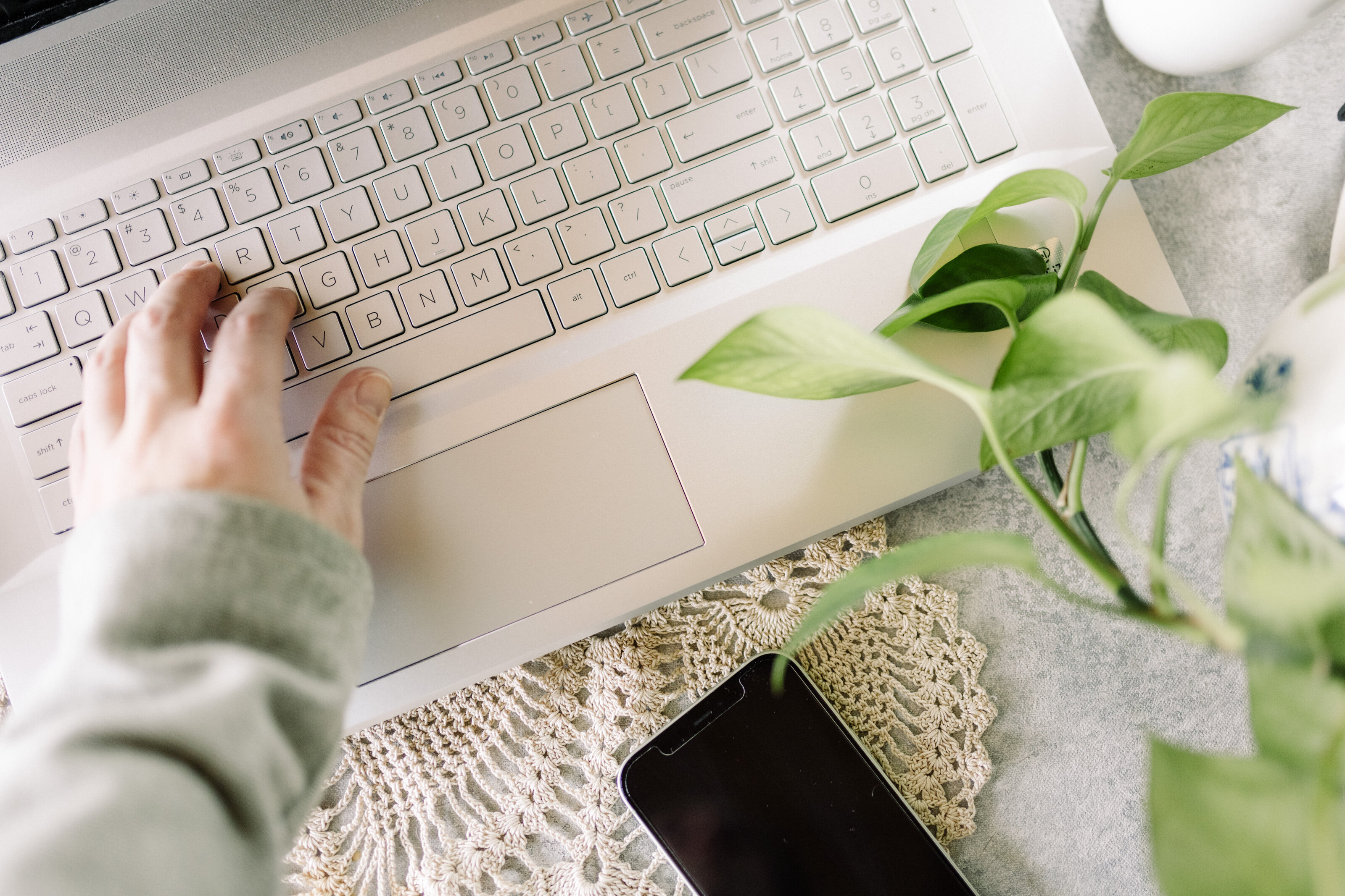 Hands typing on a laptop keyboard