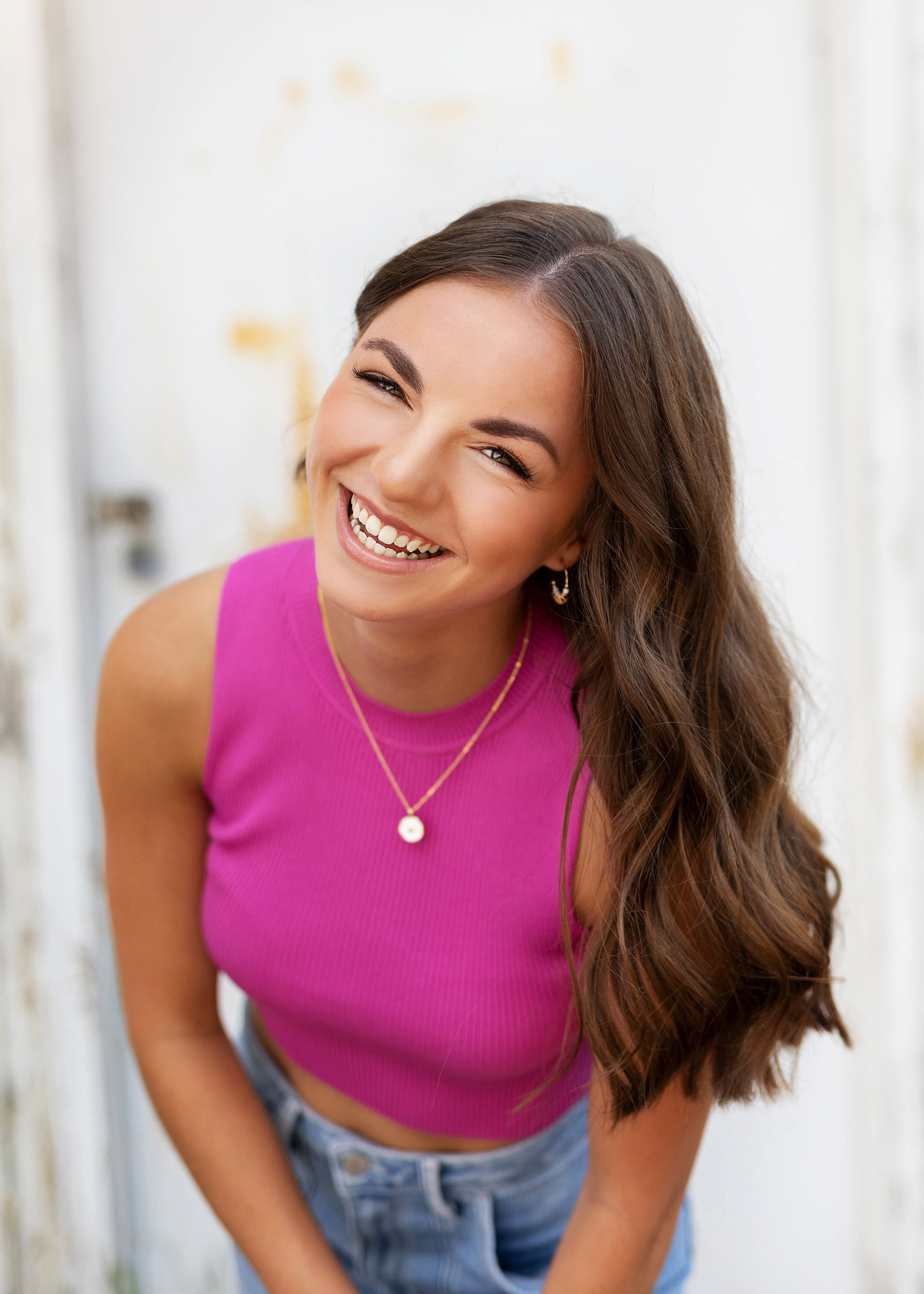 photo of minneapolis senior girl in bright pink shirt laughing during senior pictures