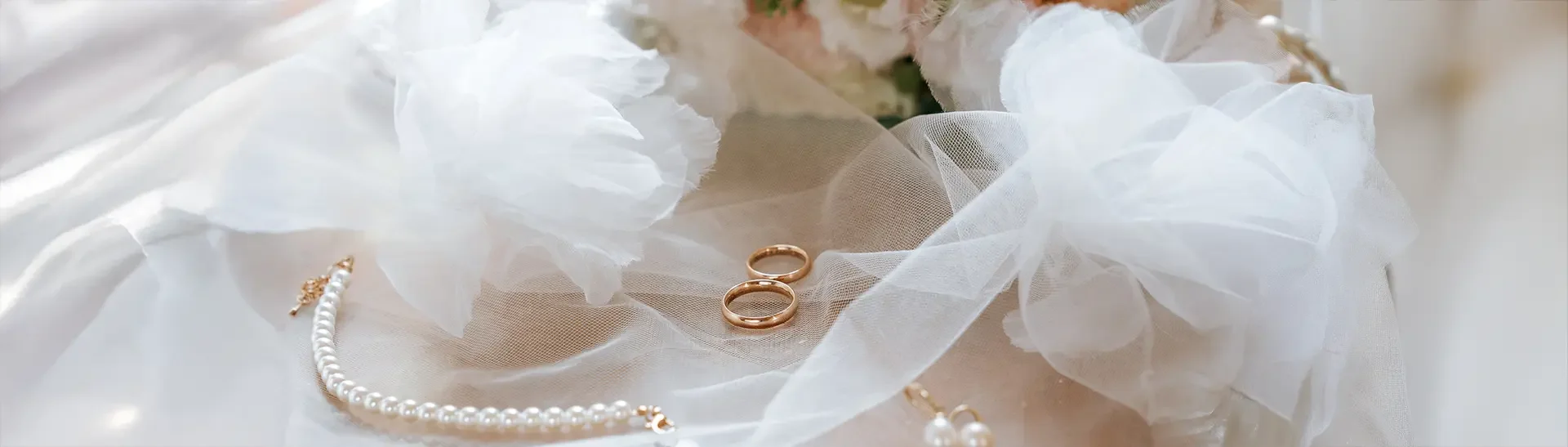 Auf dem Stuhl liegen weiße Sandalen, Schleier, getrockneter Strauß, Parfum und Herzbrille. Getting ready fotografie trifft kreative hochzeitsfotografie und setzt auf hochzeitsfotografie mit stil