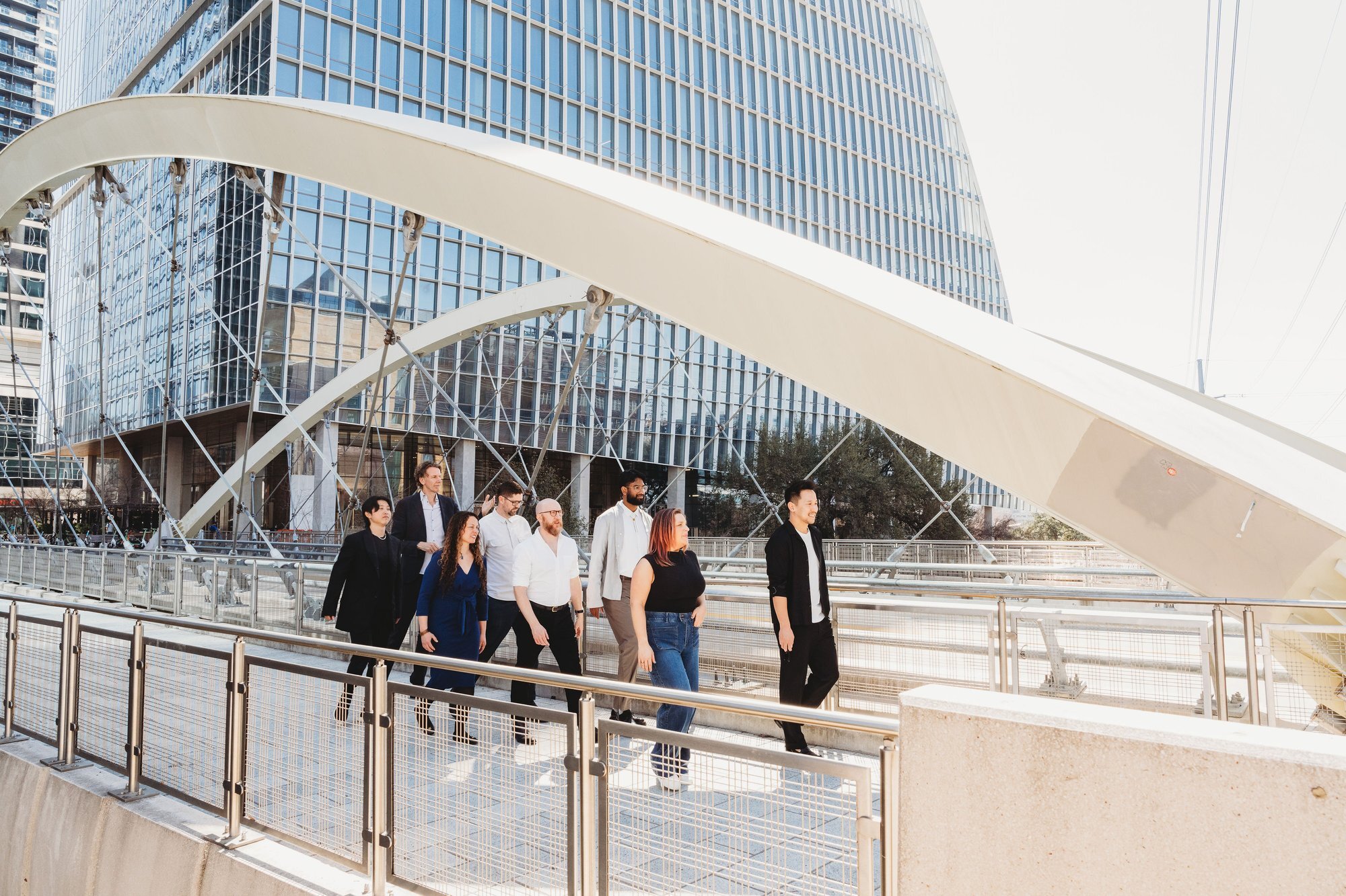 UNS architecture team walking across a pedestrian bridge in Austin