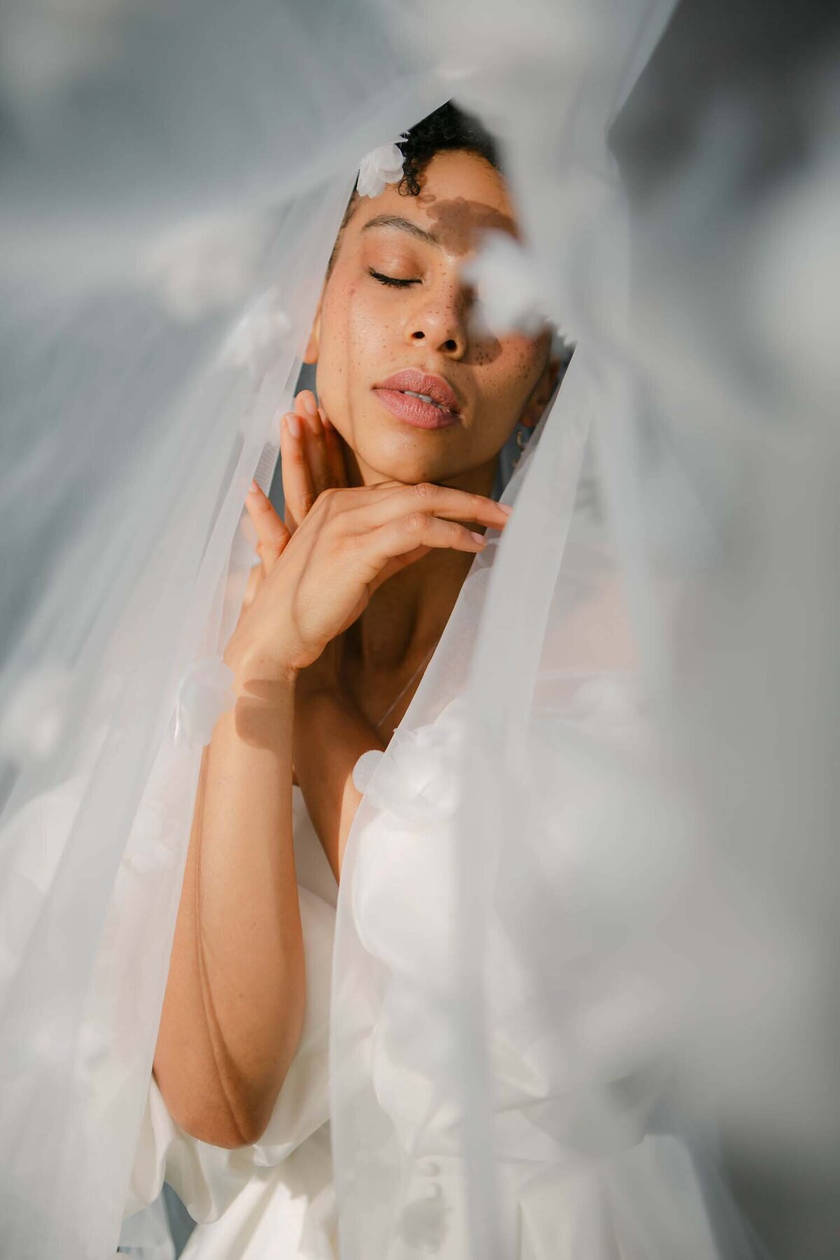 Bride with eyes closed behind a flowing veil, intimate elopement-style bridal portrait