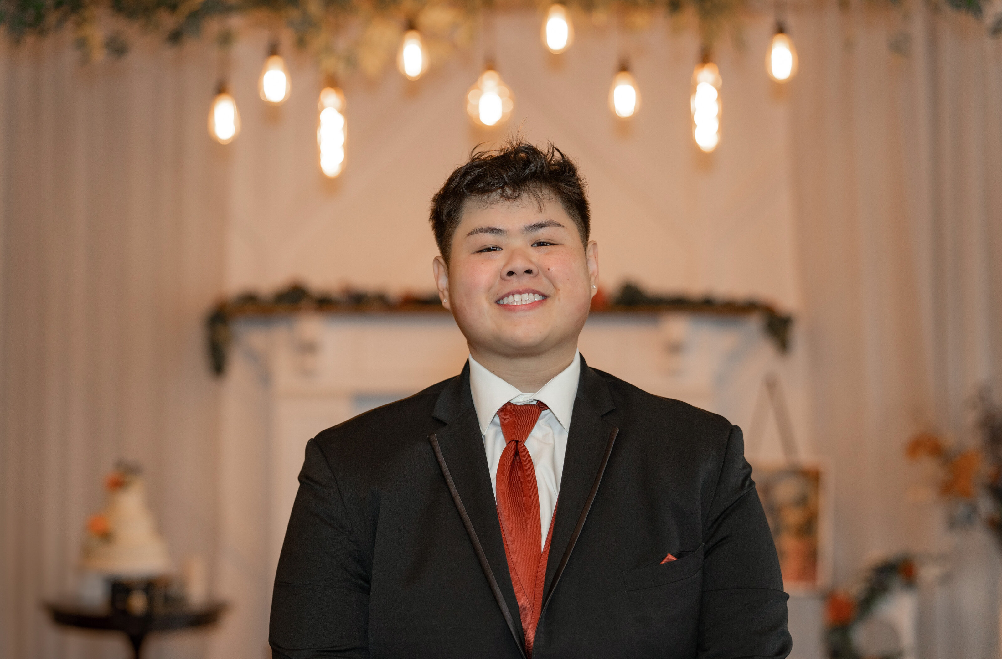 Smiling headshot in a suit and red tie