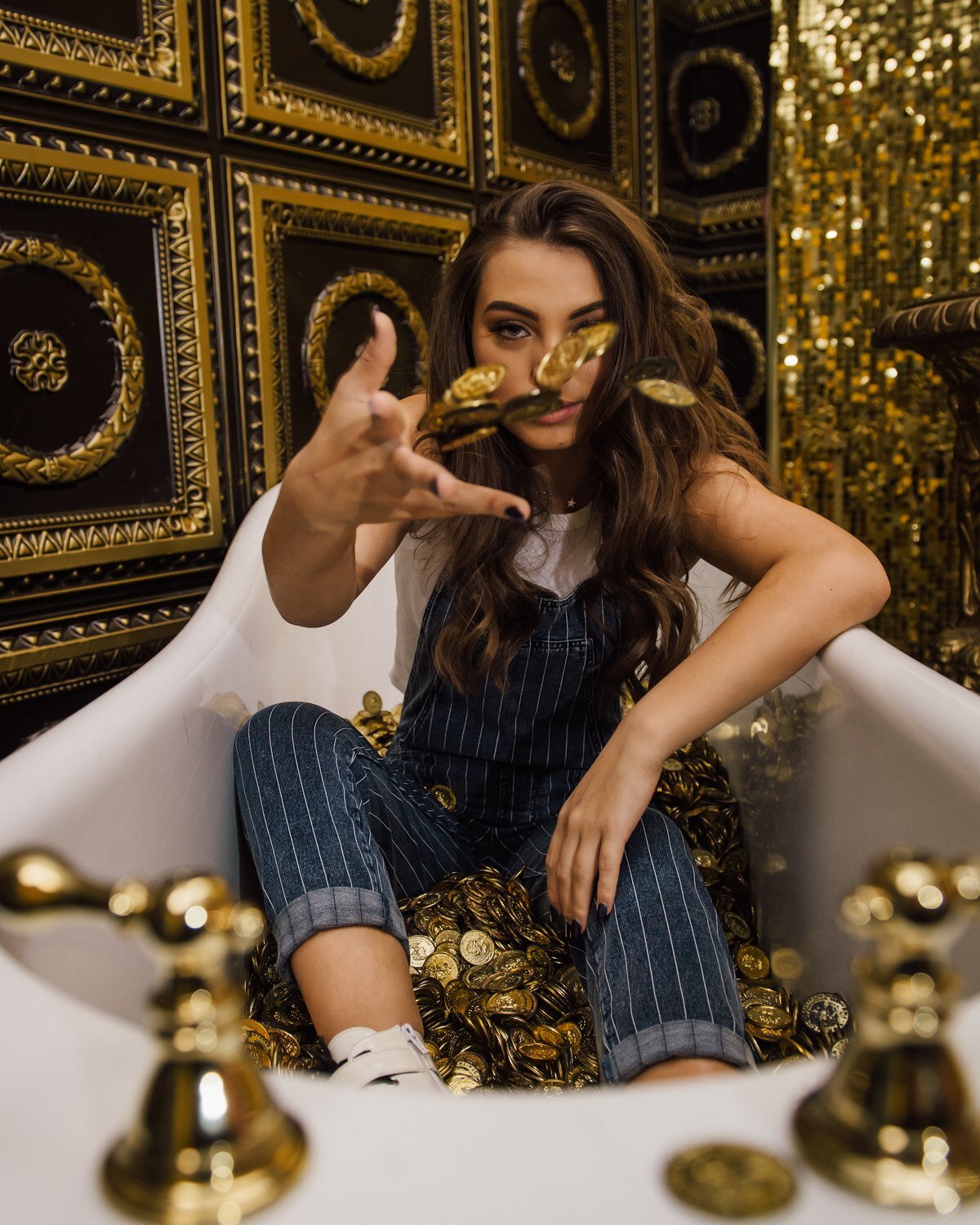High school senior sitting in a vintage bathtub full of gold coins, creative senior portrait by Renee Bowen