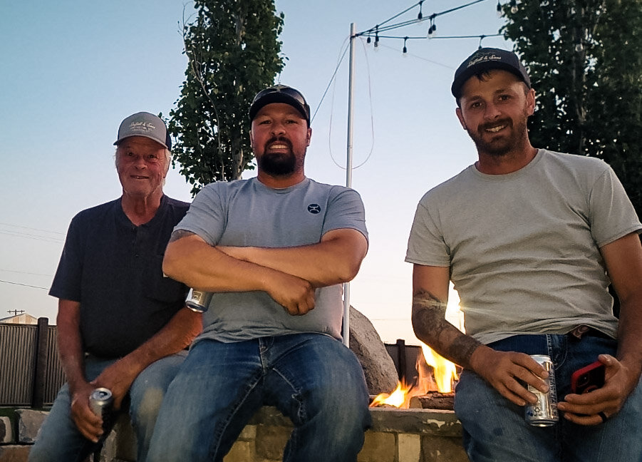 Mike, Will and Lucky Shiflett sitting together by the firepit