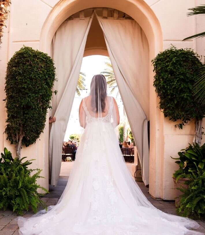 Bride entering her wedding ceremony through a draped archway
