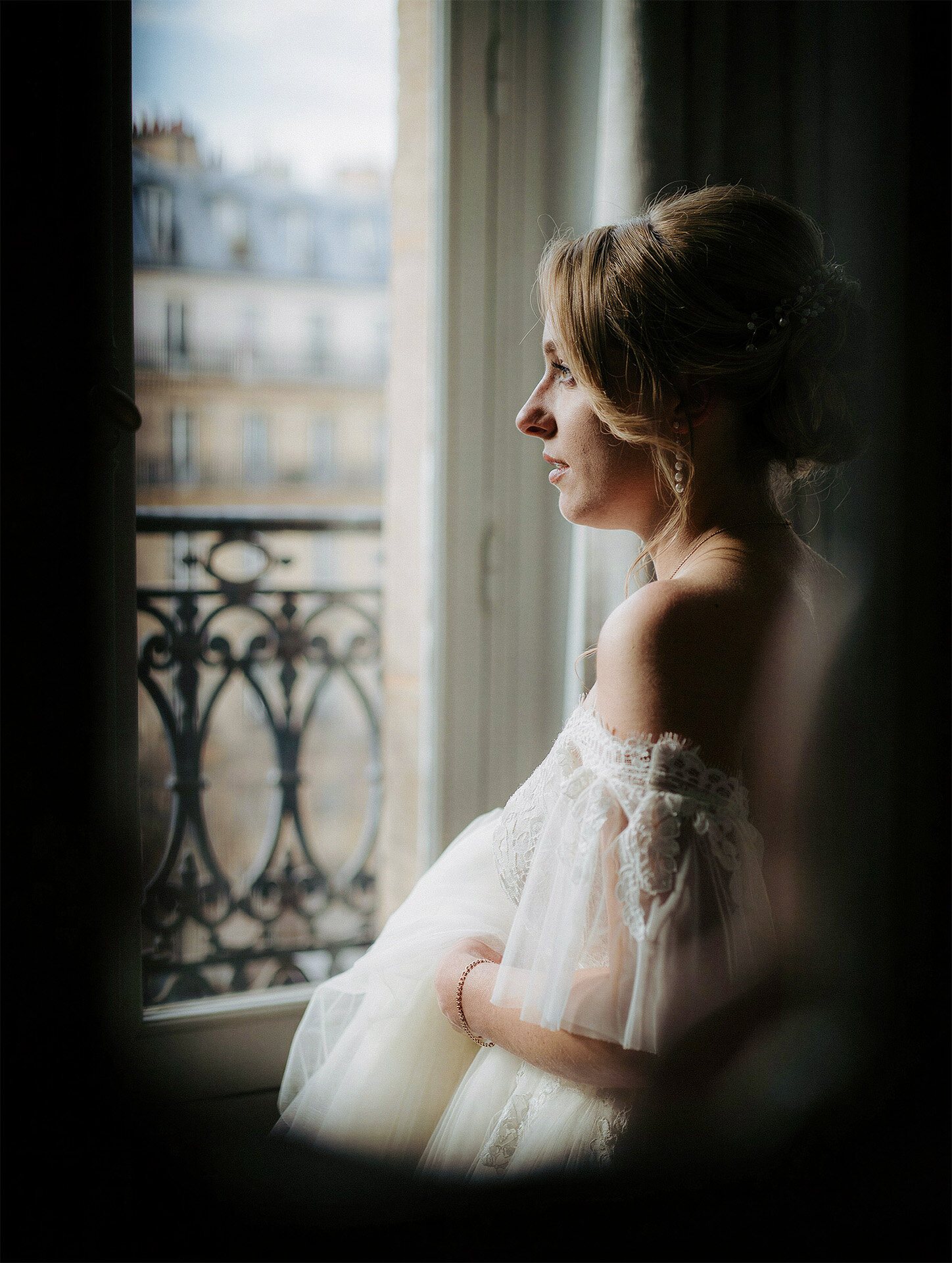 Bride at a window during a destination wedding in Paris, France