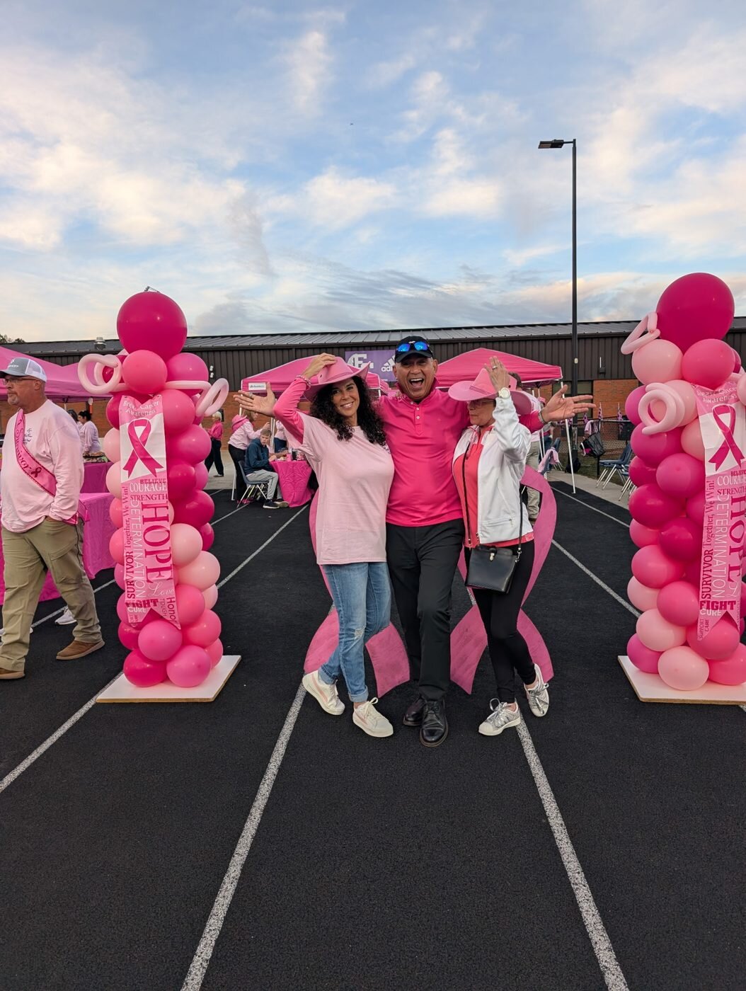 Guests in pink celebrating between pink balloon columns