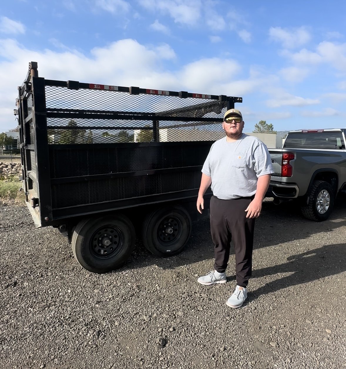 A team member beside The Load Dumper trailer and pickup truck