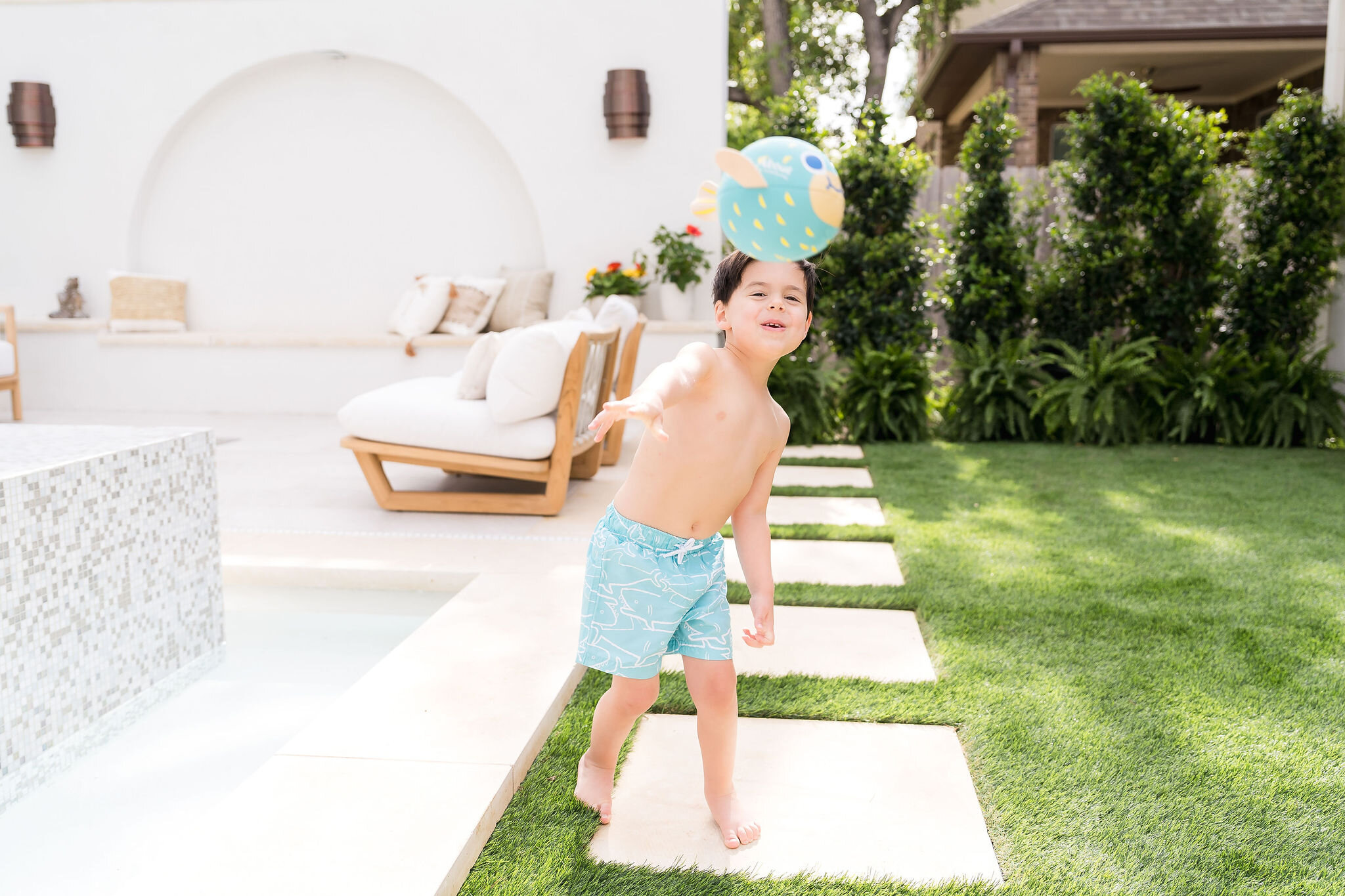 Boy wearing Splash About swim trunks poolside in Austin