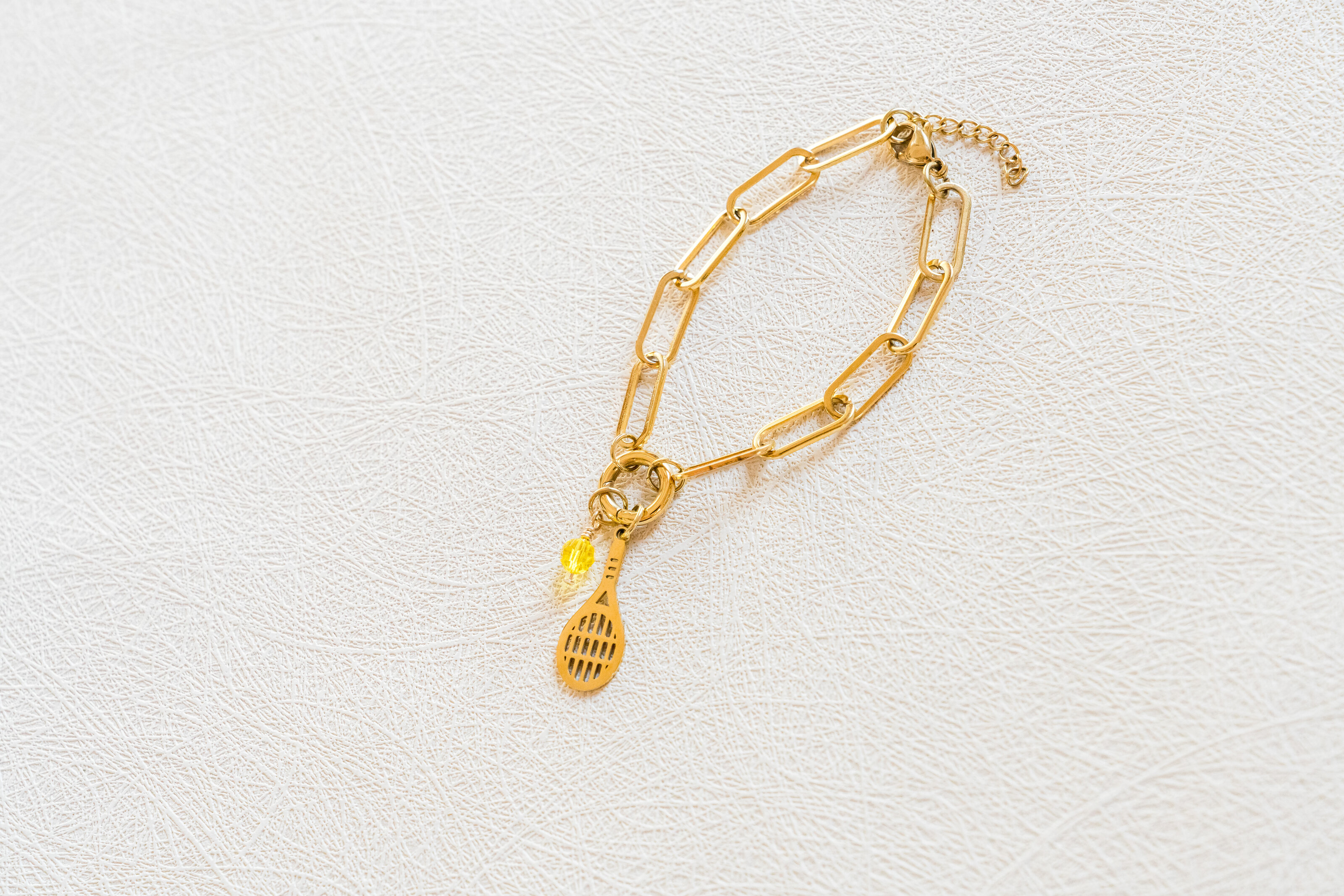 Flatlay of Charm Theory tennis racket charm bracelet
