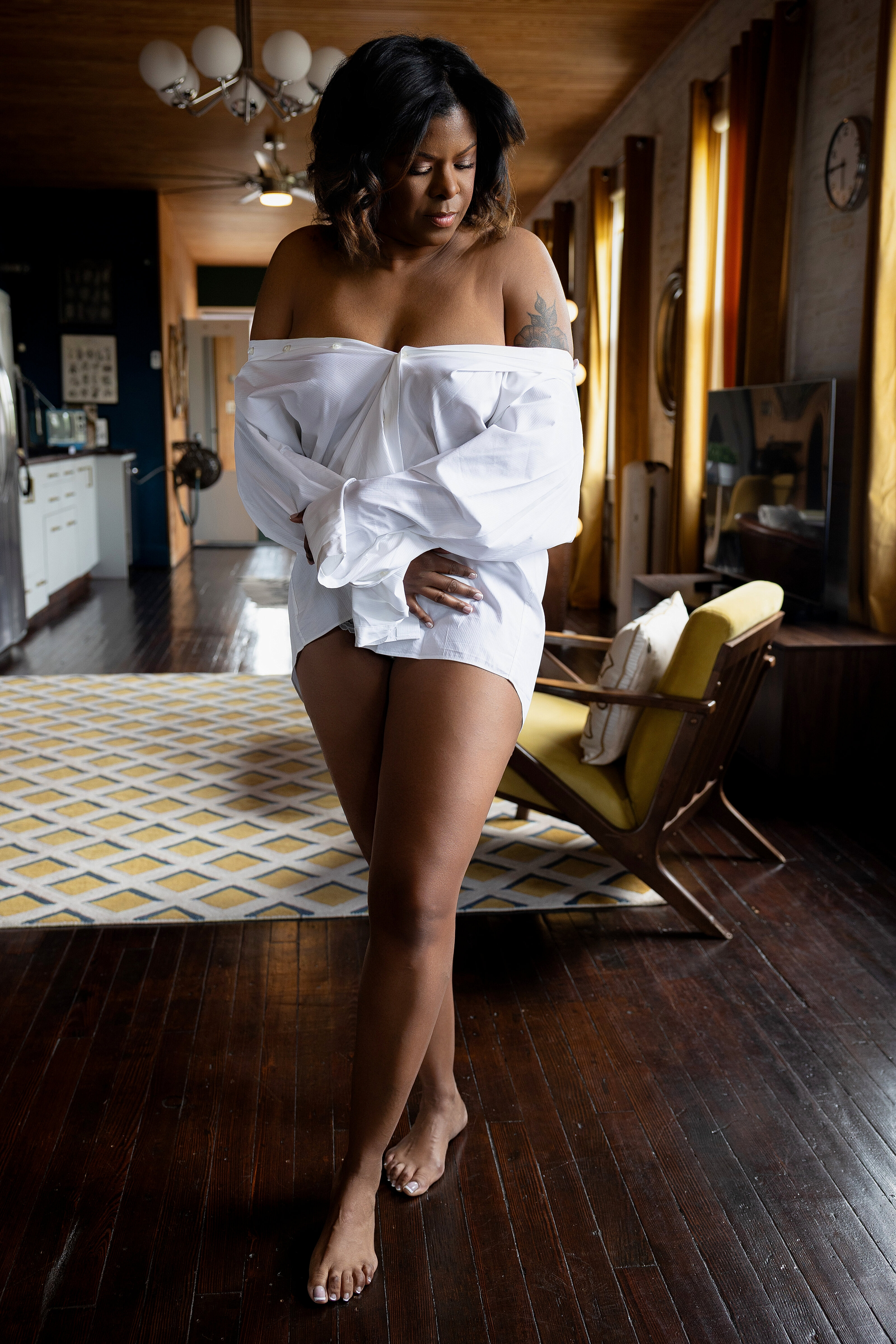 Woman wearing a white button up shirt during a boudoir session with Nicole Griffin Photography