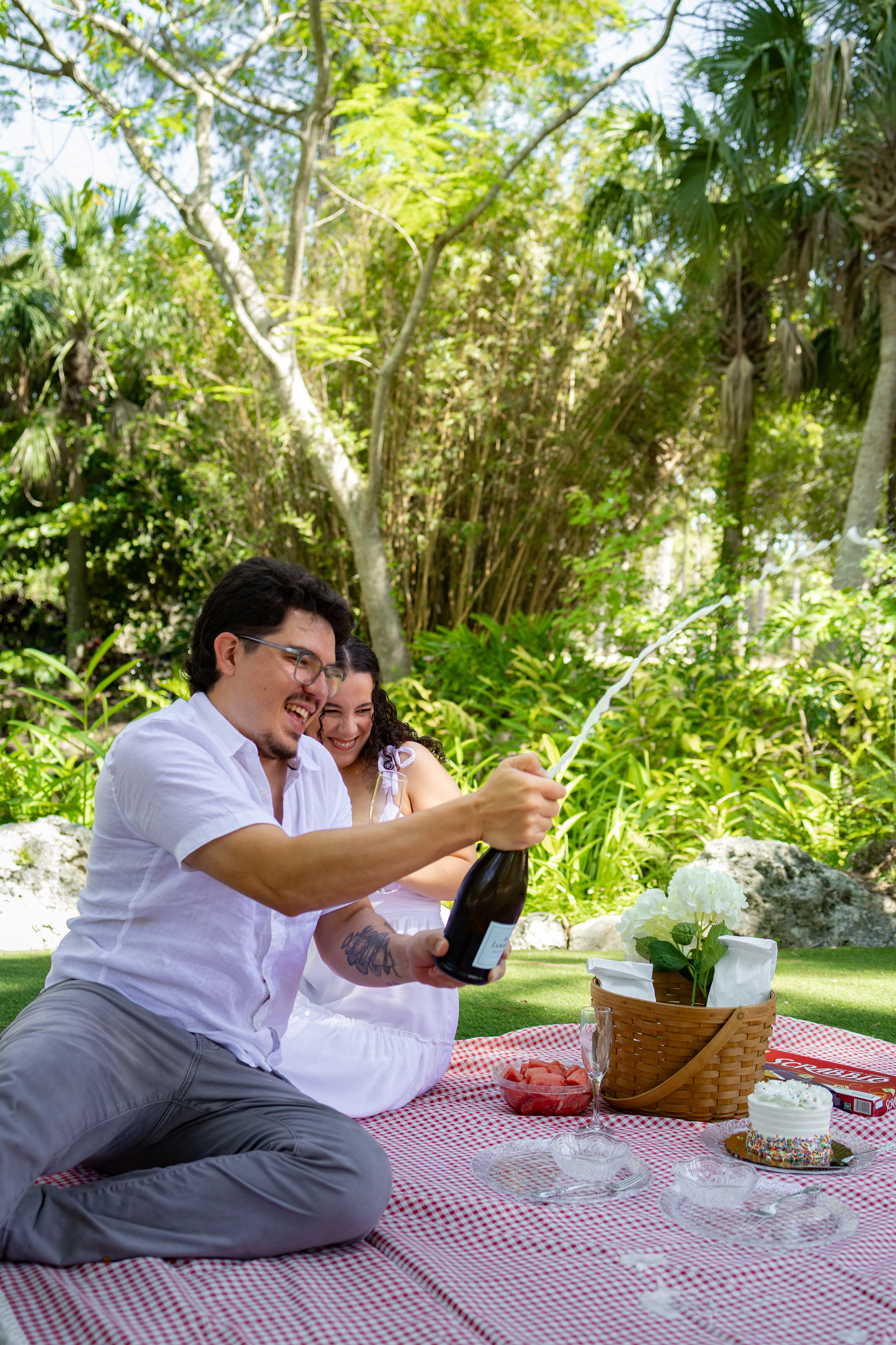 Couple popping champagne picnic elopement in Florida