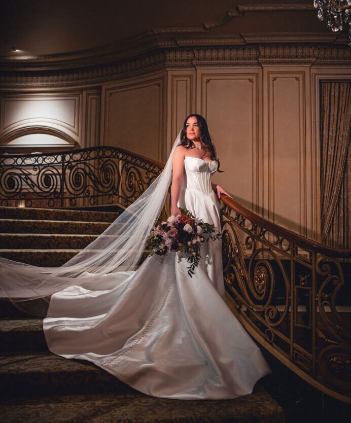 Bride holding her bouquet on an ornate grand staircase