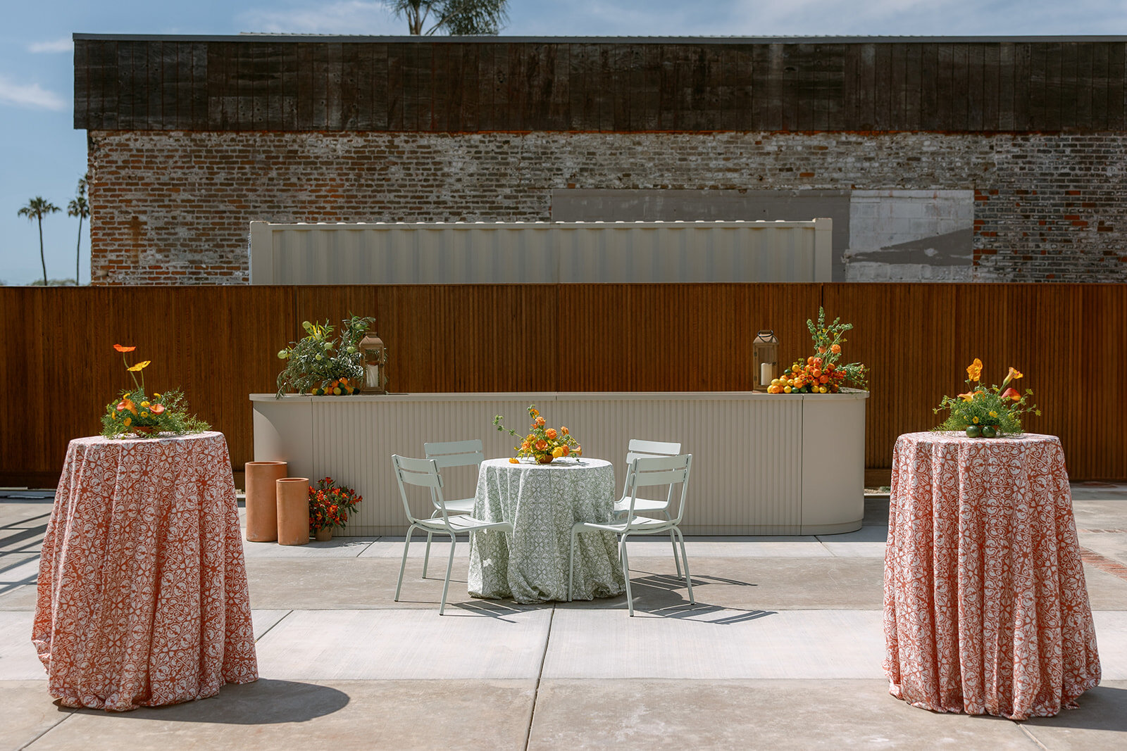 Palomino’s modular bar configured outdoors with cocktail tables, patterned linens and seasonal flowers.