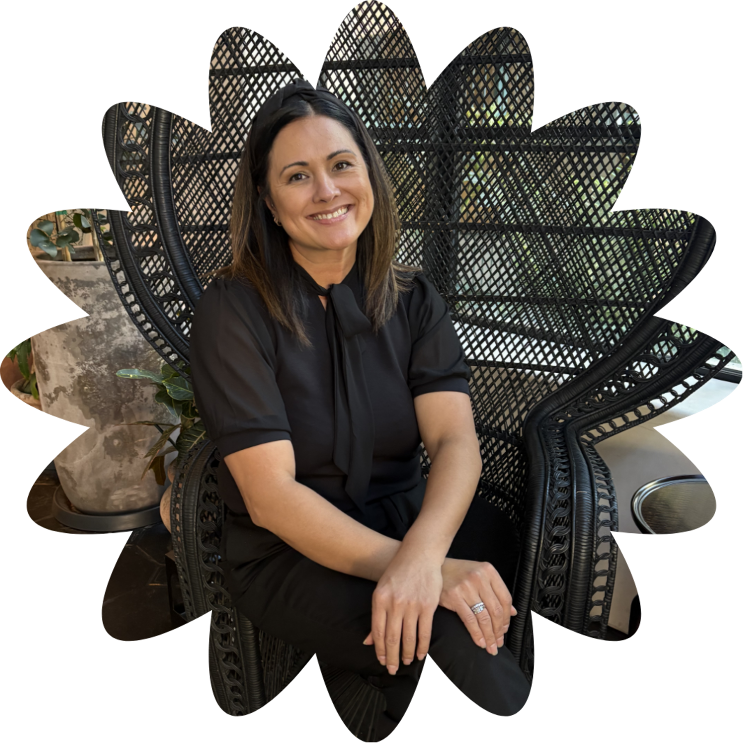 wedding coordinator client sitting on woven chair smiling