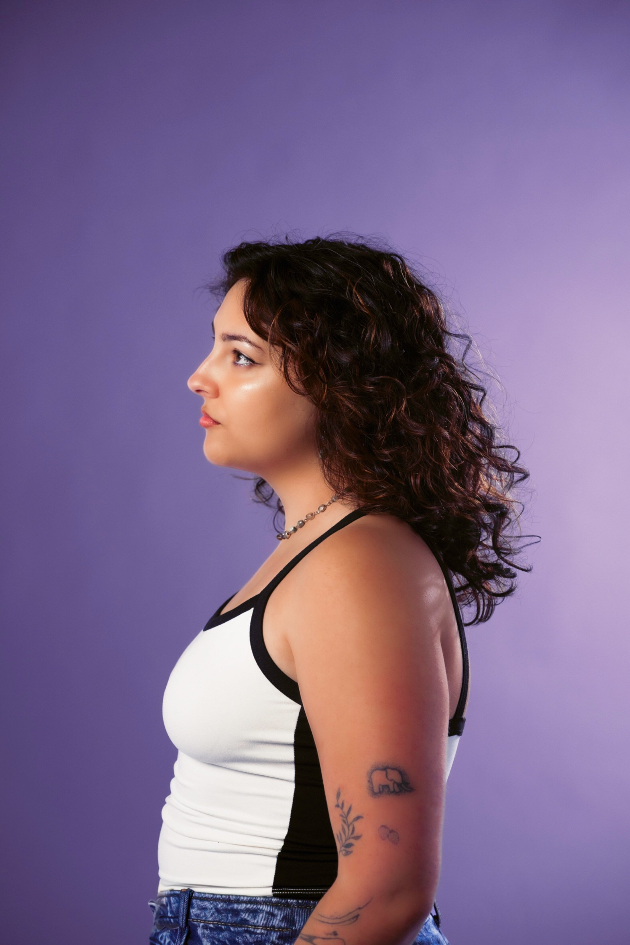 Woman poses to the right in clear lighting.