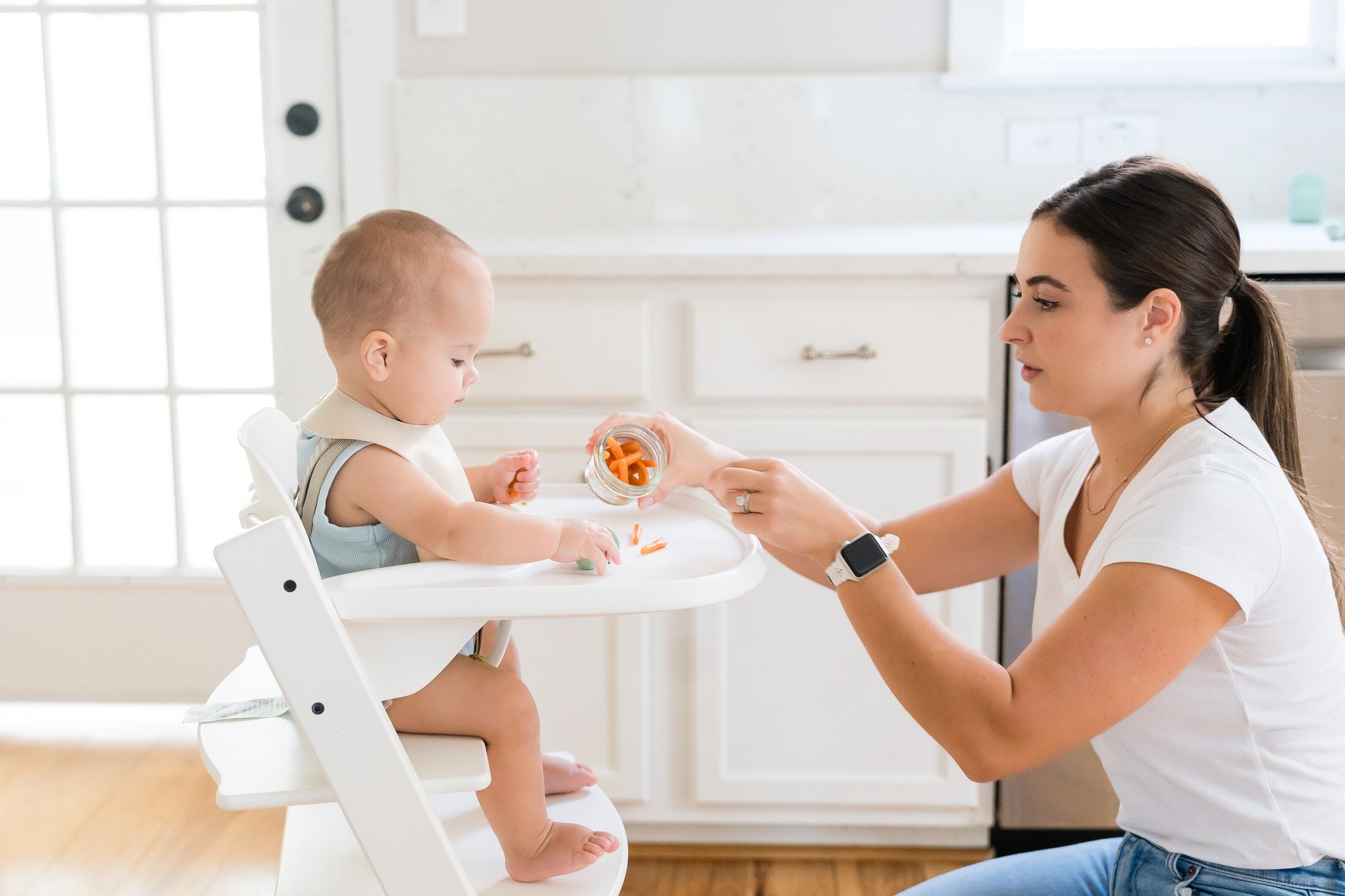 Nanny feeding a child in a highchair for Stork Maternity Consulting